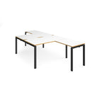 L-shaped back-to-back desks with white top with wooden edges and a black metal frame on a white background