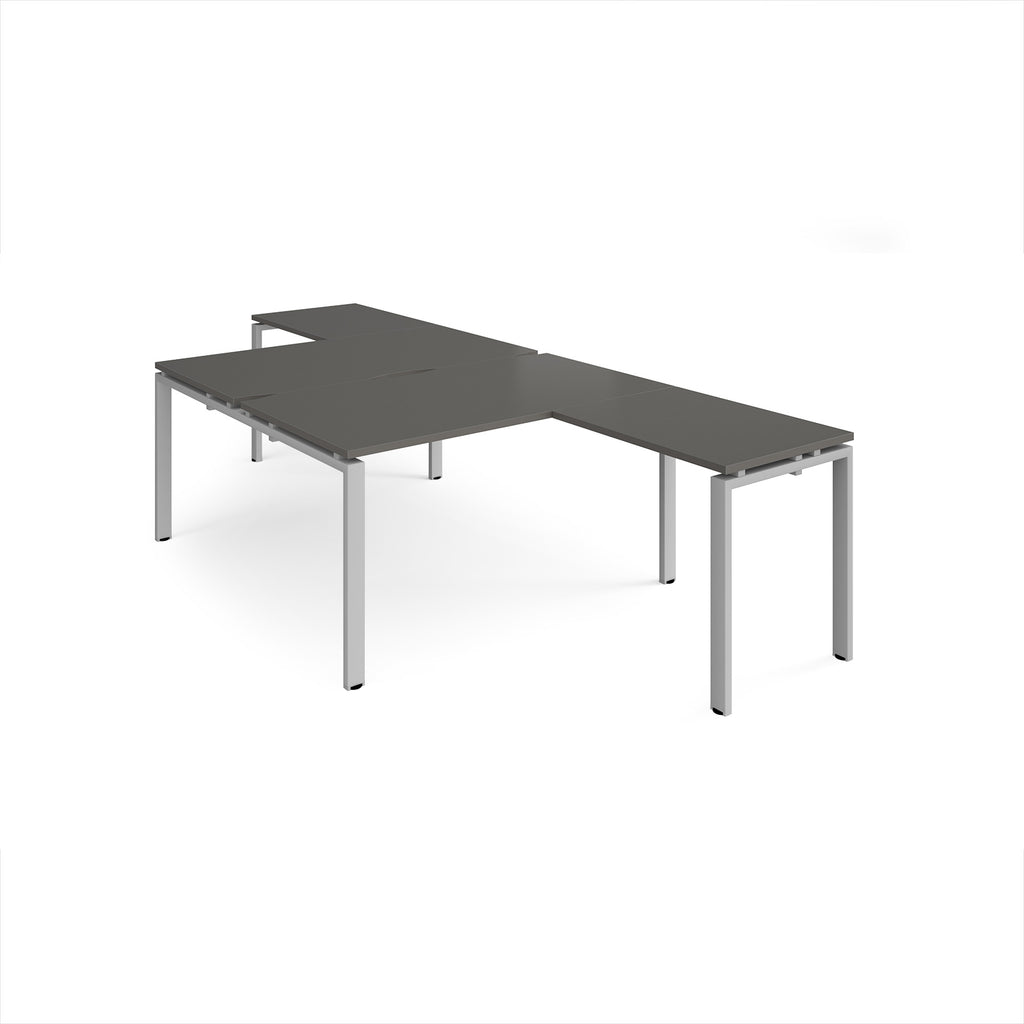 L-shaped back-to-back desks with grey top and a silver metal frame on a white background