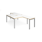 L-shaped back-to-back desks with white top with wooden edges and a silver metal frame on a white background