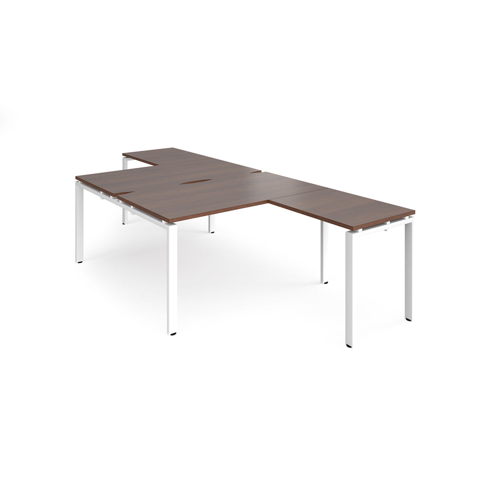 L-shaped back-to-back desks with wood-effect top and a white metal frame on a white background