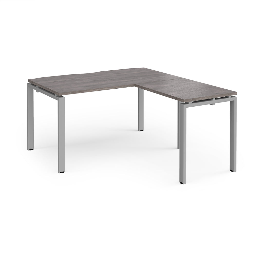 L-shaped desk with grey wood-effect top and silver metal frame on a white background