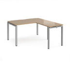 L-shaped desk with wood-effect top and silver metal frame on a white background