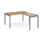 L-shaped desk with wood-effect top and silver metal frame on a white background