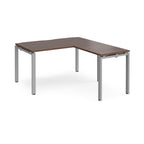 L-shaped desk with wood-effect top and silver metal frame on a white background