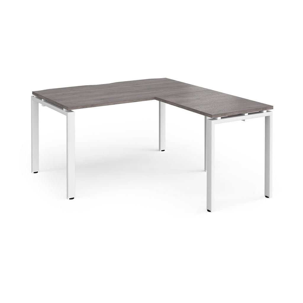 L-shaped desk with grey wood-effect top and white metal frame on a white background