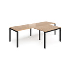 L-shaped back-to-back desks with wood-effect top and black metal legs on a white background