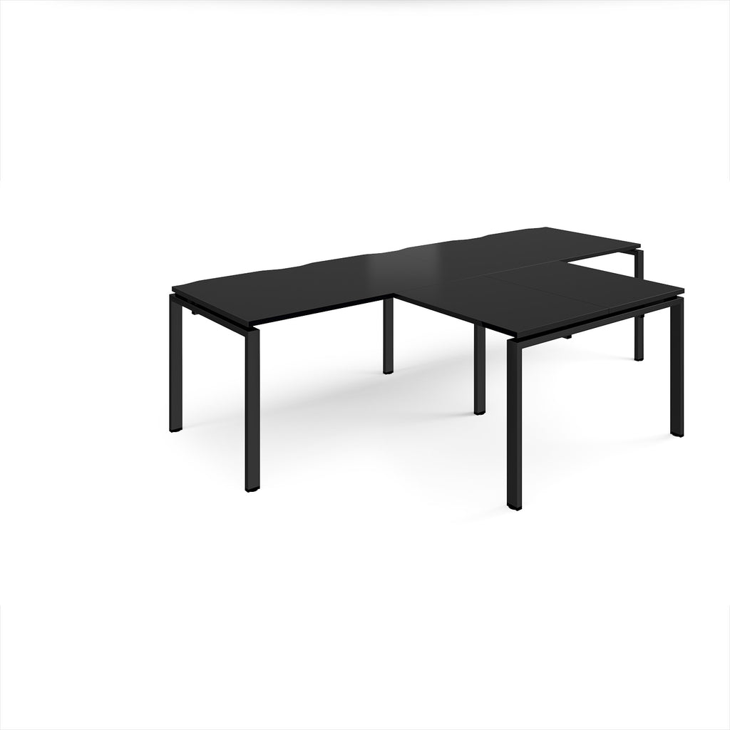 Black L-shaped back-to-back desks with metal legs on a white background