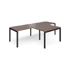 L-shaped back-to-back desks with wood-effect top and black metal legs on a white background