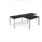L-shaped back-to-back desks with black top and silver metal legs on a white background