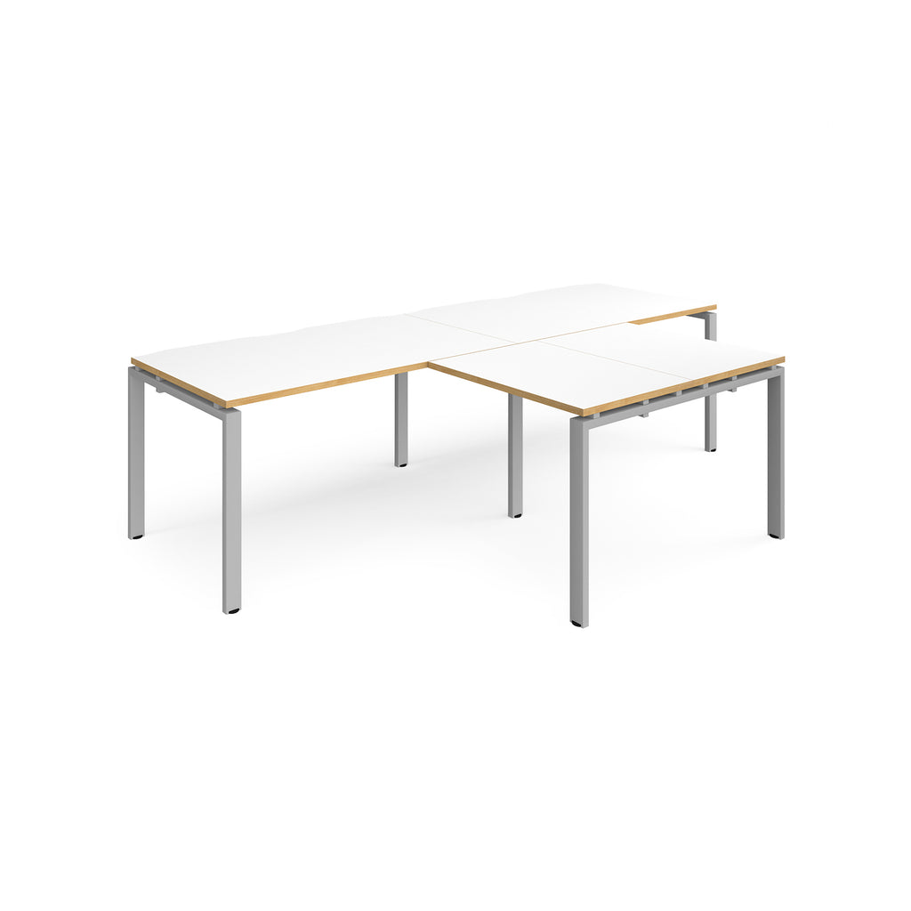 L-shaped back-to-back desks with white top with wooden edges and silver metal legs on a white background