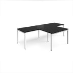 L-shaped back-to-back desks with black top and white metal legs on a white background