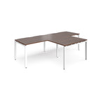 L-shaped back-to-back desks with wood-effect top and white metal legs on a white background