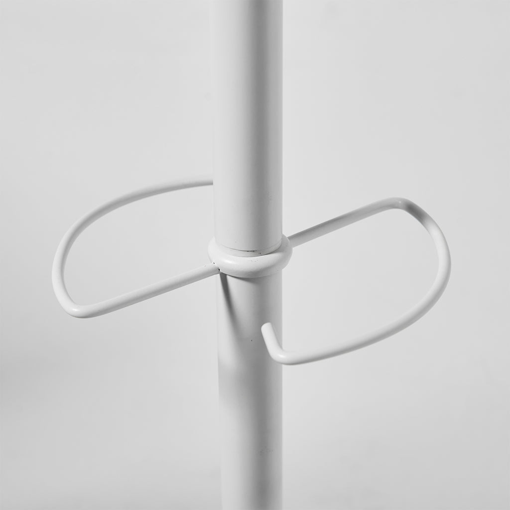 A close-up of a white metal coat rack with a central vertical pole and a curved horizontal hook at the centre, shown against a light grey background.