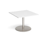 Square table with white top and brushed steel pedestal base on a white background