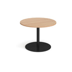 Round wooden table with a black base on a white background