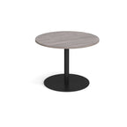 Round table with a light wooden top and black round base on a white background