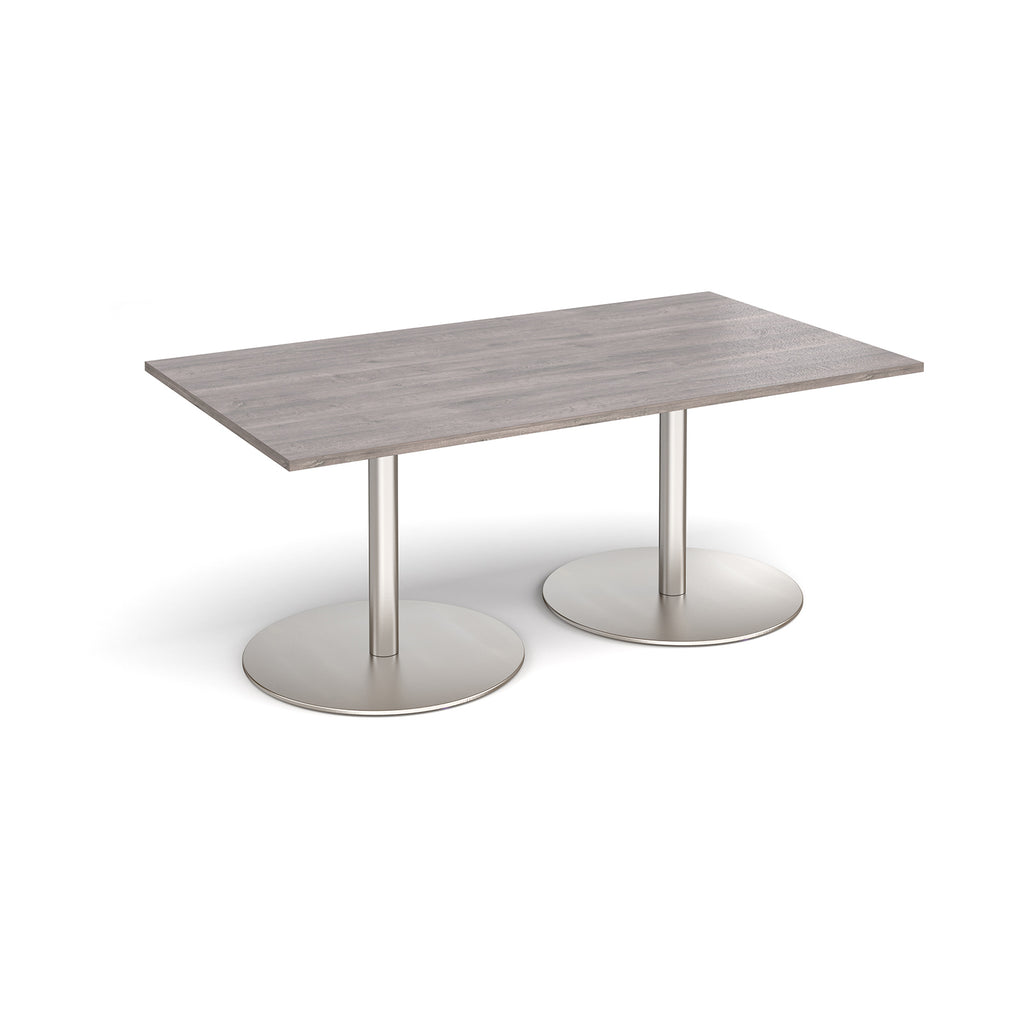 A rectangular meeting table with a grey wood-effect top and two round brushed steel pedestal bases, shown on a clean white background.