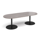 A modern oval conference table with a grey wood-grain top and dual black metal pedestal bases, shown on a clean white background.