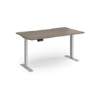 Height adjustable desk with wood-effect top and silver metal frame on a white background