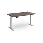 Height adjustable desk with wood-effect top and silver metal frame on a white background