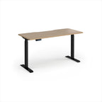 A modern height-adjustable desk with a light oak wood-grain top and black metal legs, shown on a clean white background.