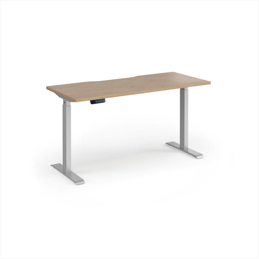 A modern height-adjustable desk with a light oak wood-grain top and silver metal legs, shown on a clean white background.