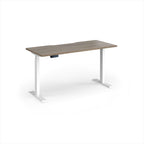 A modern height-adjustable desk with a grey wood-grain top and white metal legs, shown on a clean white background.