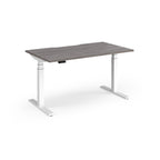 Sit-stand desk with grey wood-effect top and white legs on a white background