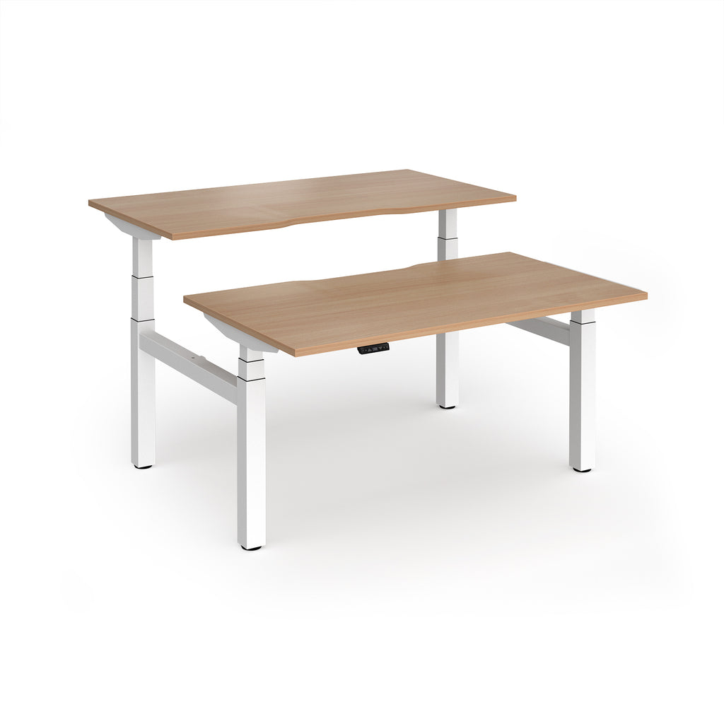 Two back-to-back height adjustable desks with shared white metal frame and wood-effect tops on a white background