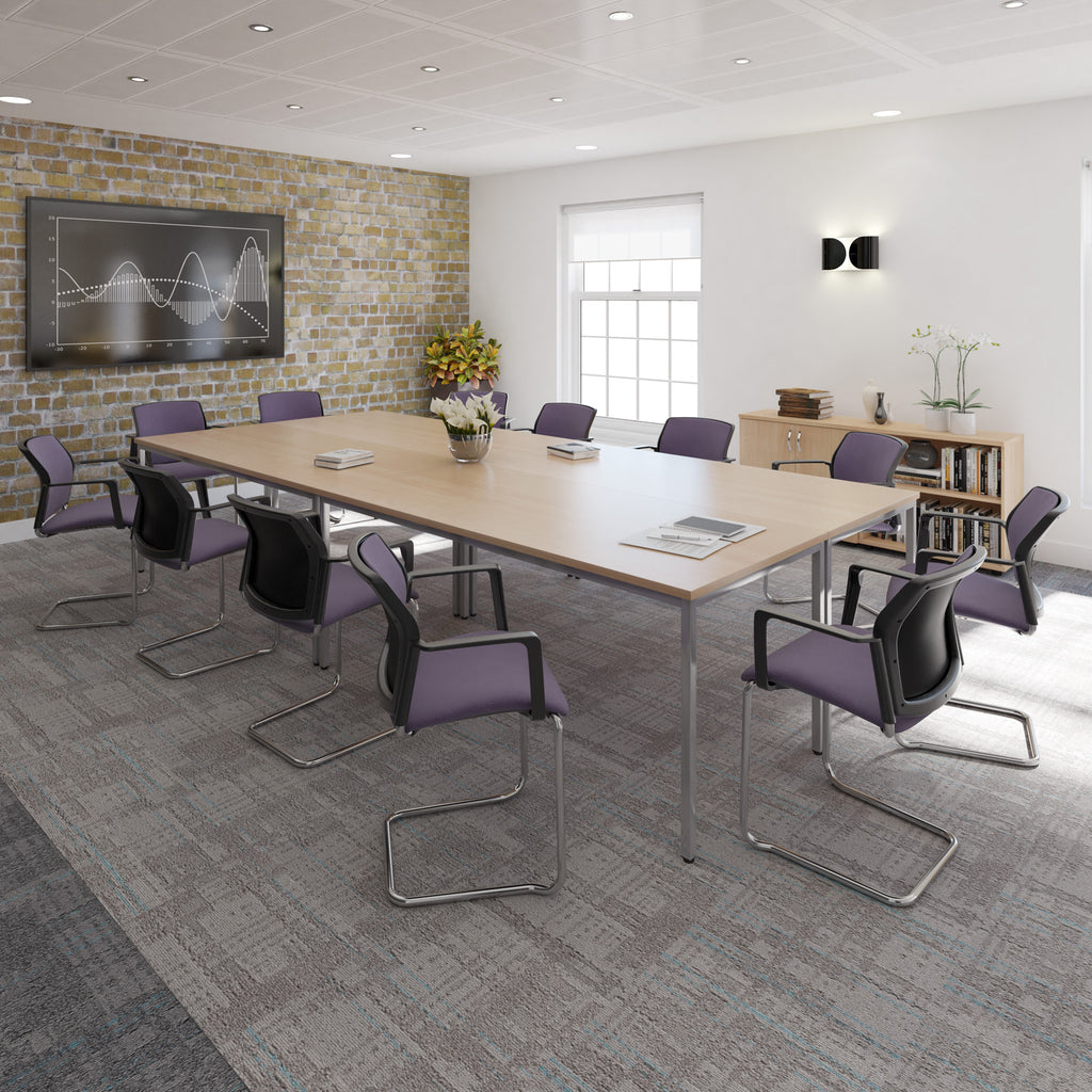 Modern conference room with a large table and chairs, featuring a brick wall and large window.