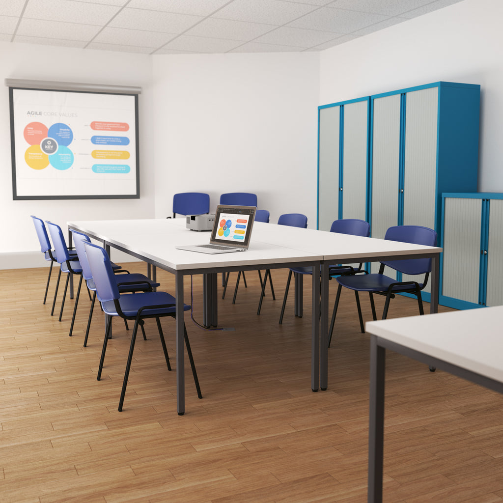 Modern office meeting room with blue chairs, a whiteboard, and a laptop on a table.