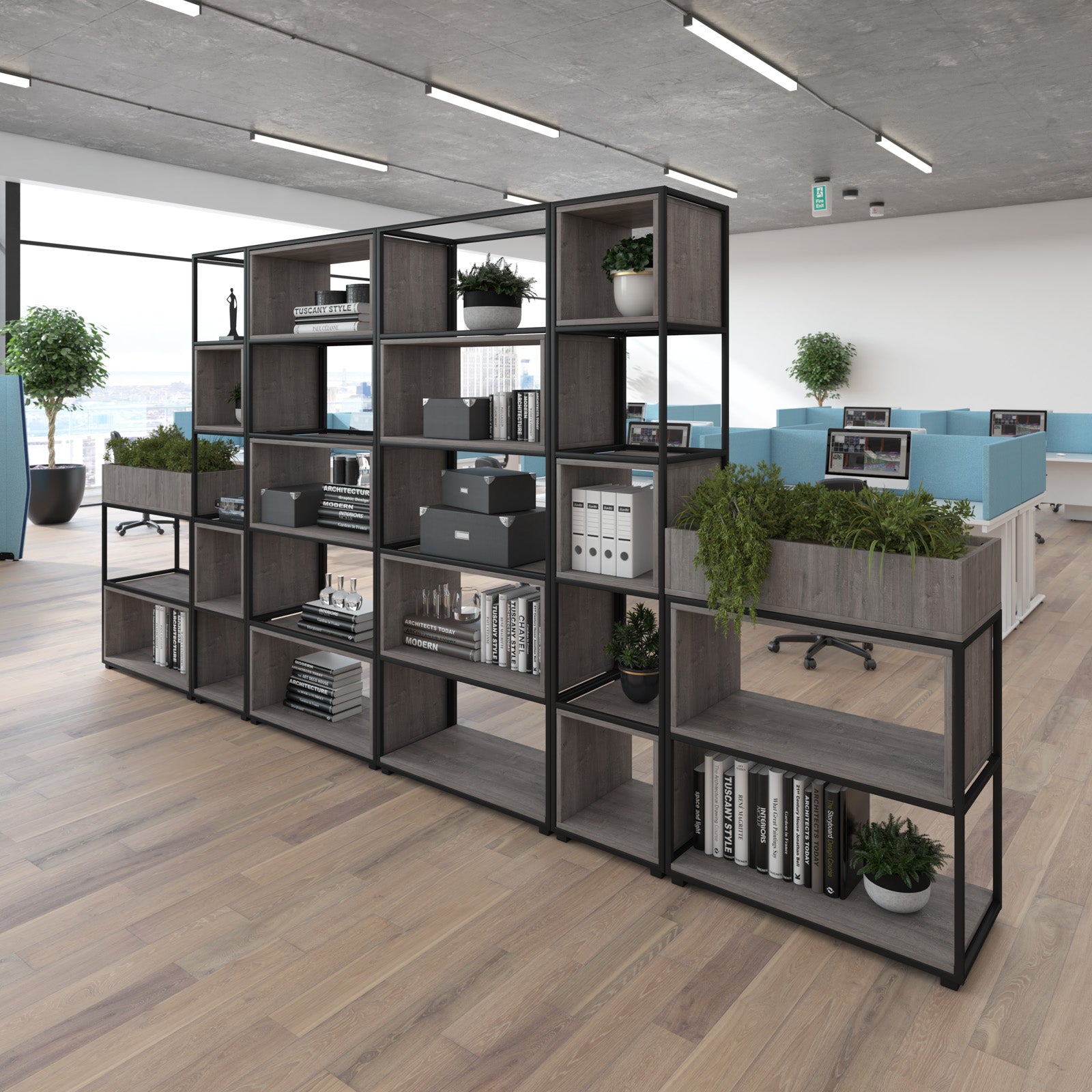 A large modular open shelving unit with dark grey wood-grain panels and black metal framing, styled with books, plants, and storage boxes in a modern office environment.