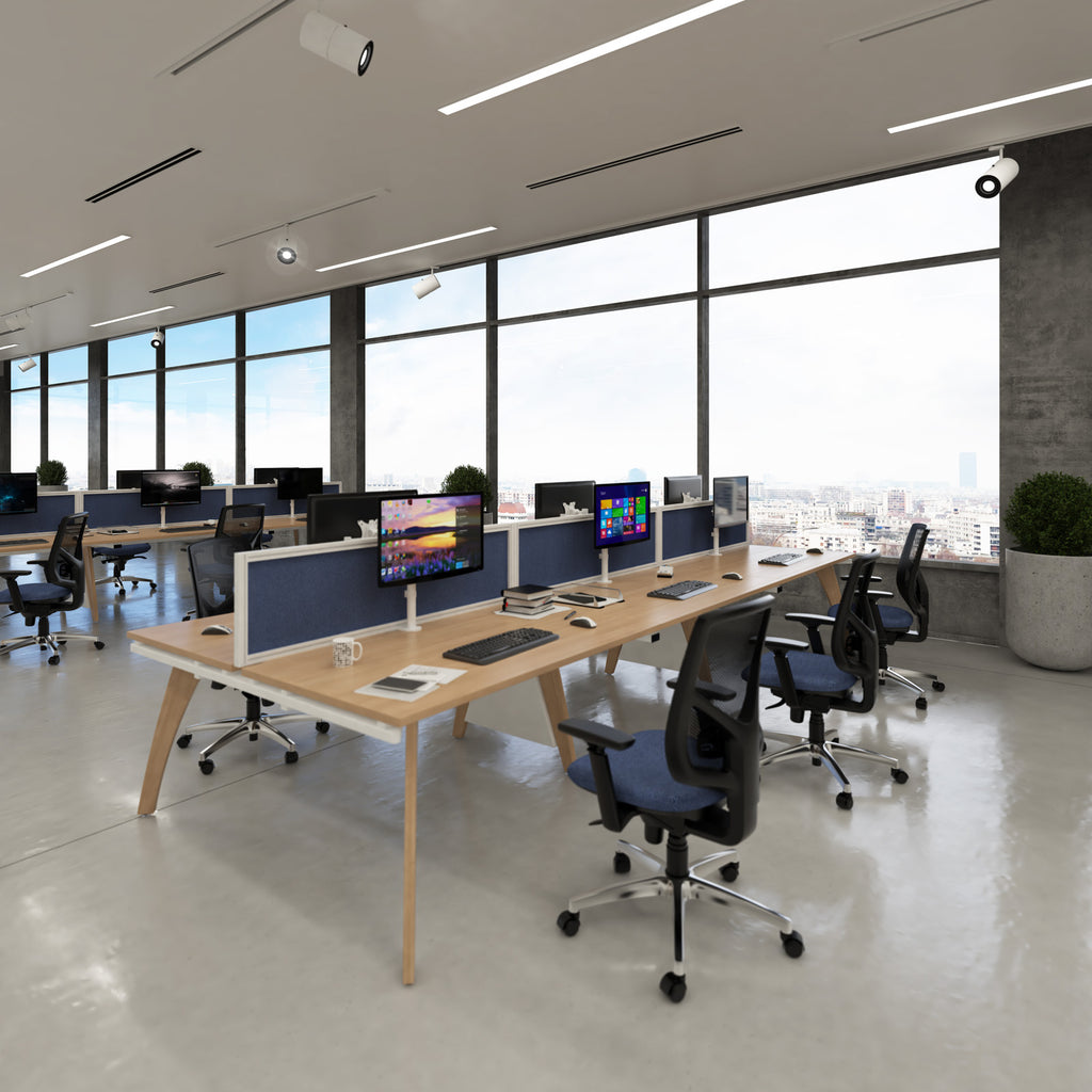 Modern office space with desks, chairs, and computer monitors.