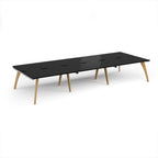 Long back-to-back wooden desk with black top on a white background