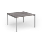 Back-to-back desk with grey wood-effect top and silver metal frame on a white background