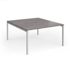 Office back-to-ack desk with grey wood-effect top and silver metal frame on a white background