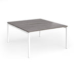 Office back-to-ack desk with grey wood-effect top and white metal frame on a white background