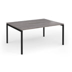 Back-to-back desk with grey wood-effect top and black metal frame on a white background