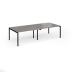 Office bench desks with grey wood-effect top and black legs on a white background
