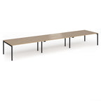Triple back-to-back desk with wood-effect top and black legs on a white background