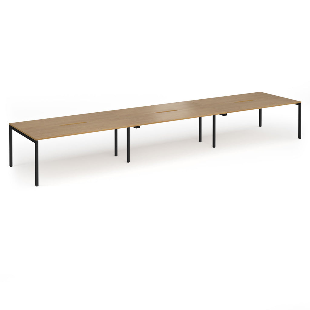 Triple back-to-back desk with wood-effect top and black legs on a white background