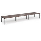 Triple back-to-back desk with wood-effect top and black legs on a white background