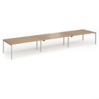 Triple back-to-back desk with wood-effect top and silver legs on a white background
