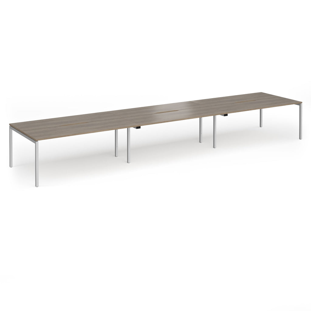 Triple back-to-back desk with wood-effect top and silver legs on a white background