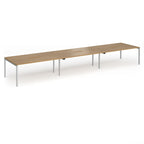 Triple back-to-back desk with wood-effect top and silver legs on a white background