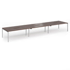 Triple back-to-back desk with wood-effect top and silver legs on a white background