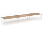 Triple back-to-back desk with wood-effect top and white legs on a white background