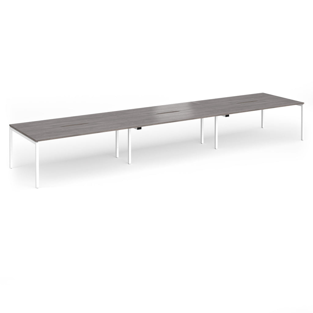 Triple back-to-back desk with grey wood-effect top and white legs on a white background