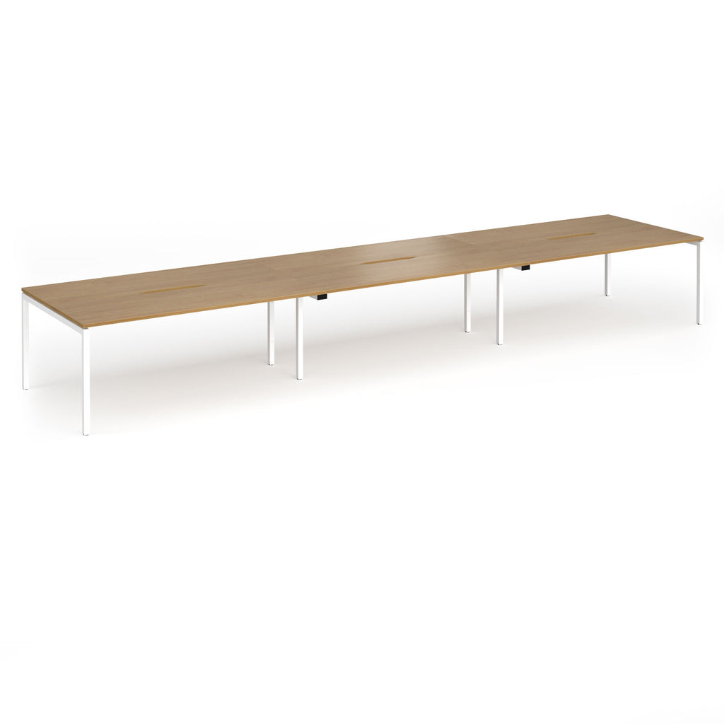 Triple back-to-back desk with wood-effect top and white legs on a white background