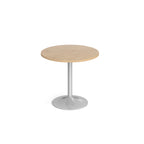 A modern round dining table with a wood-effect top and a silver pedestal base, shown on a seamless white background.